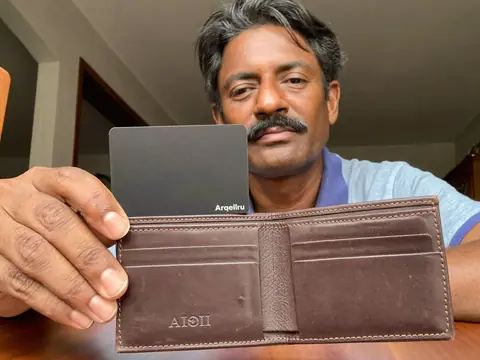 A man shows the Arqellio card in his wallet